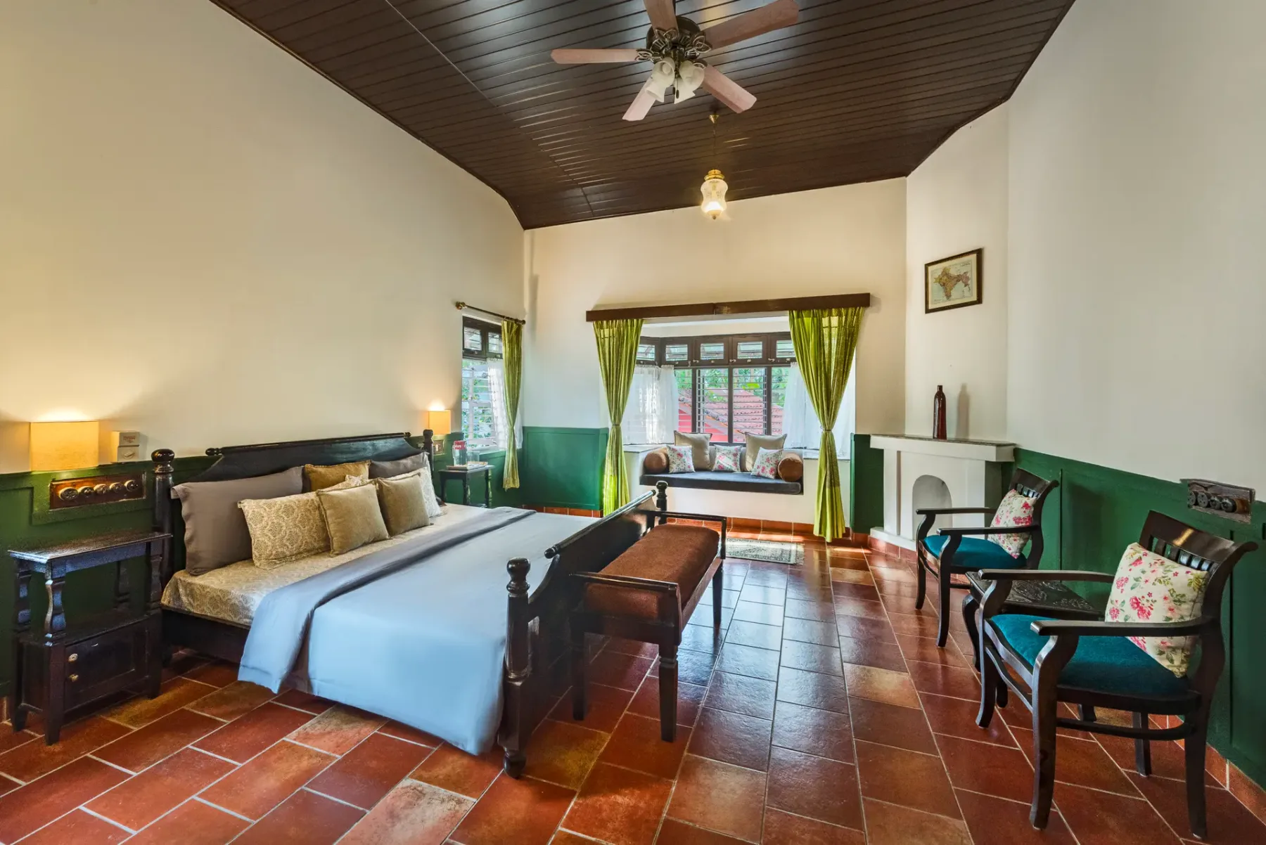 A bedroom with a bed, dark wood ceiling, and green lower walls.