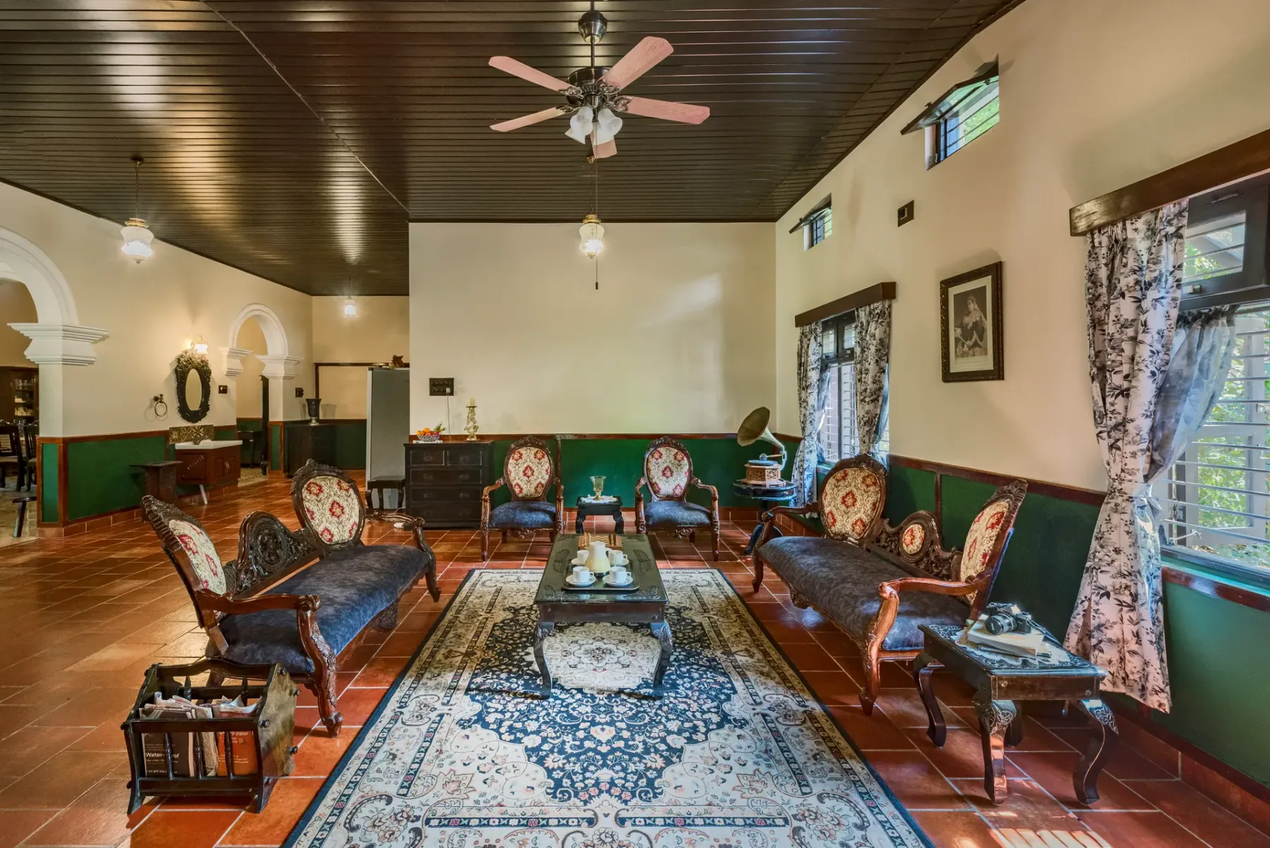 A sitting room with seating arranged around a coffee table and patterned rug.