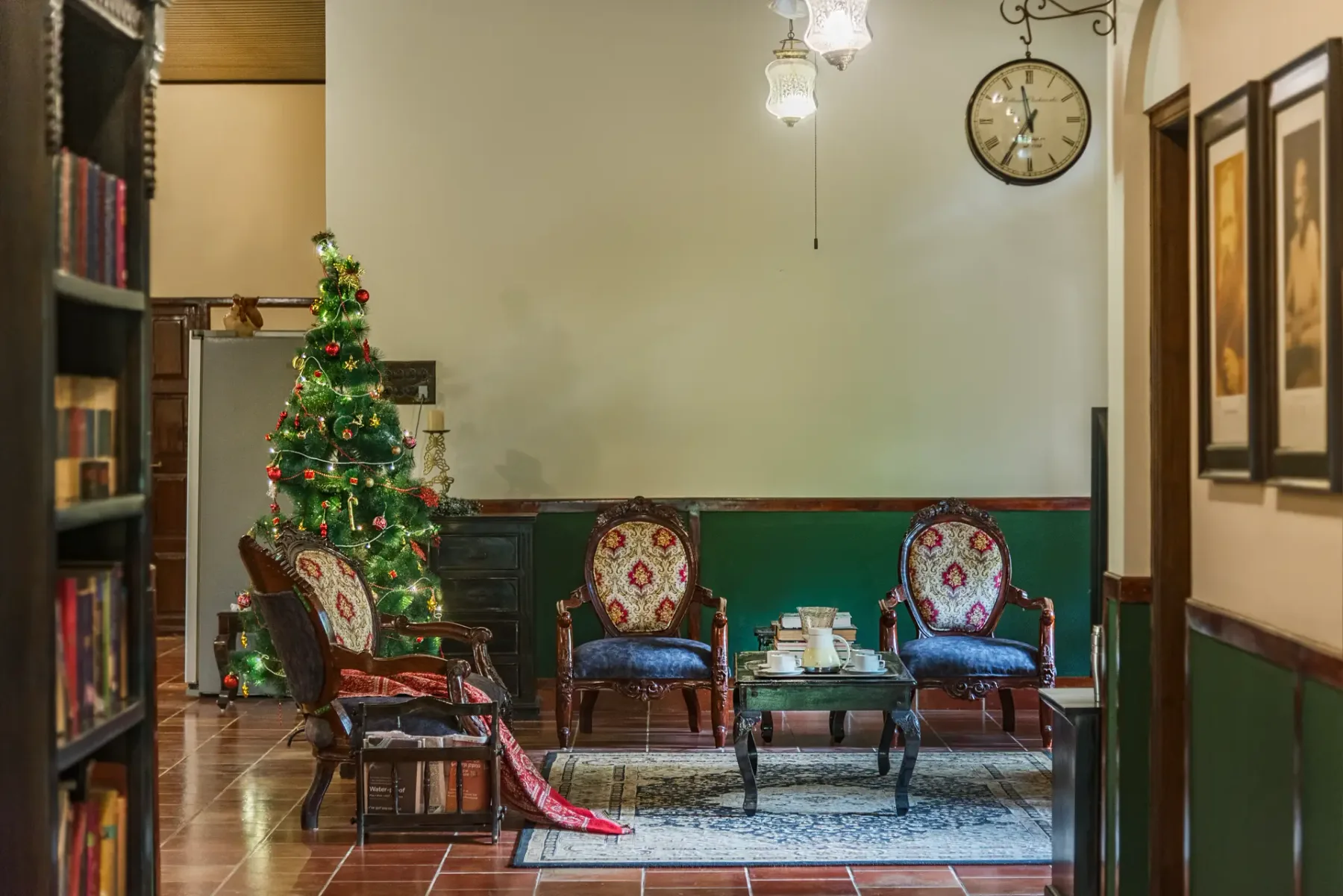 A sitting room with patterned chairs, a coffee table, and a decorated Christmas tree.