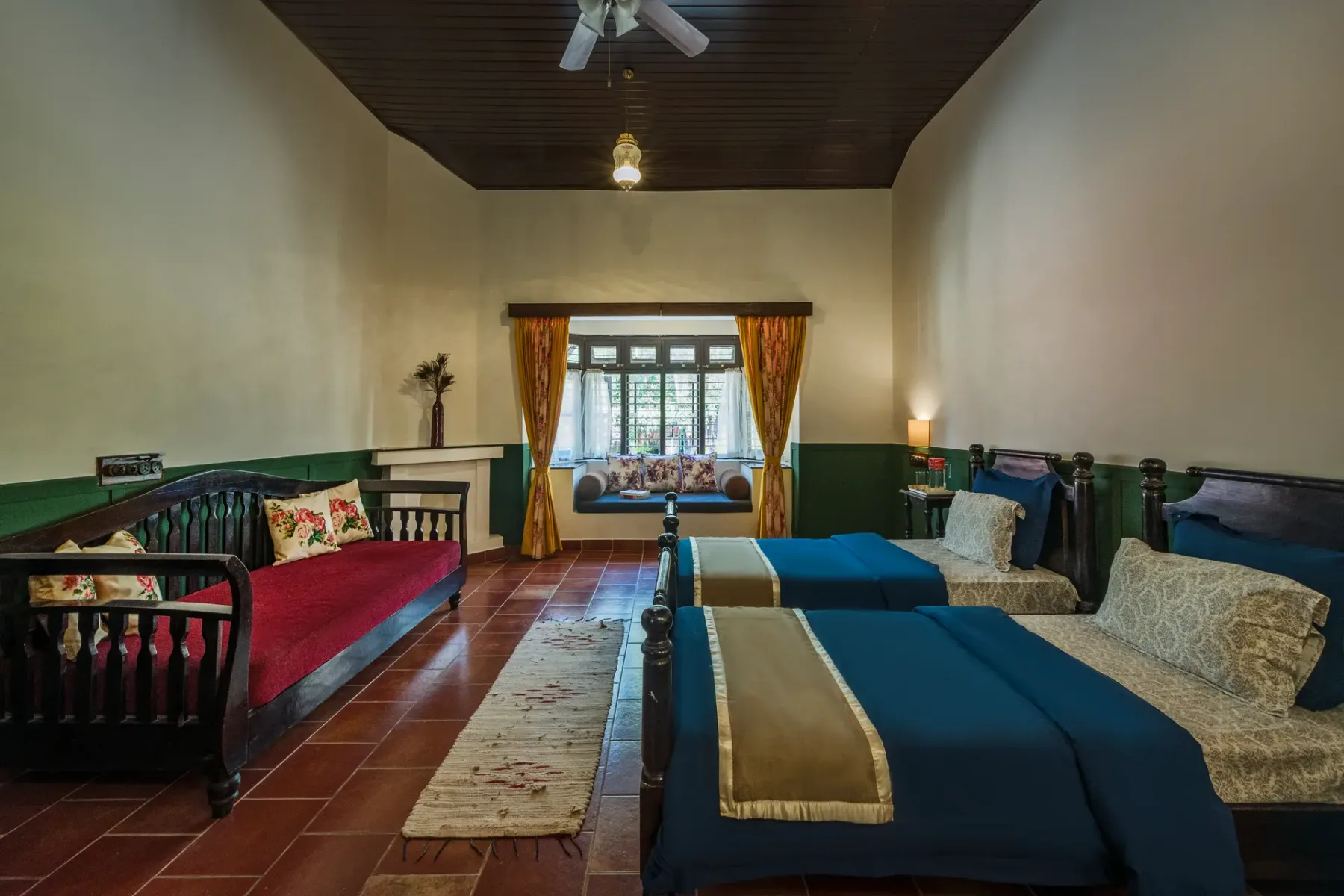 A bedroom with beds arranged around a window and a narrow rug.