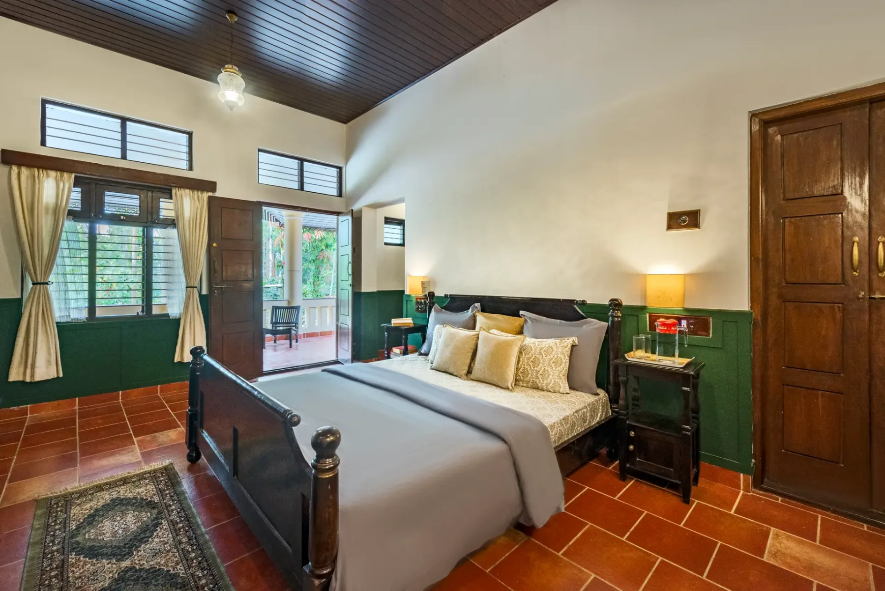 A bedroom with a bed, windows, and dark wood ceiling.