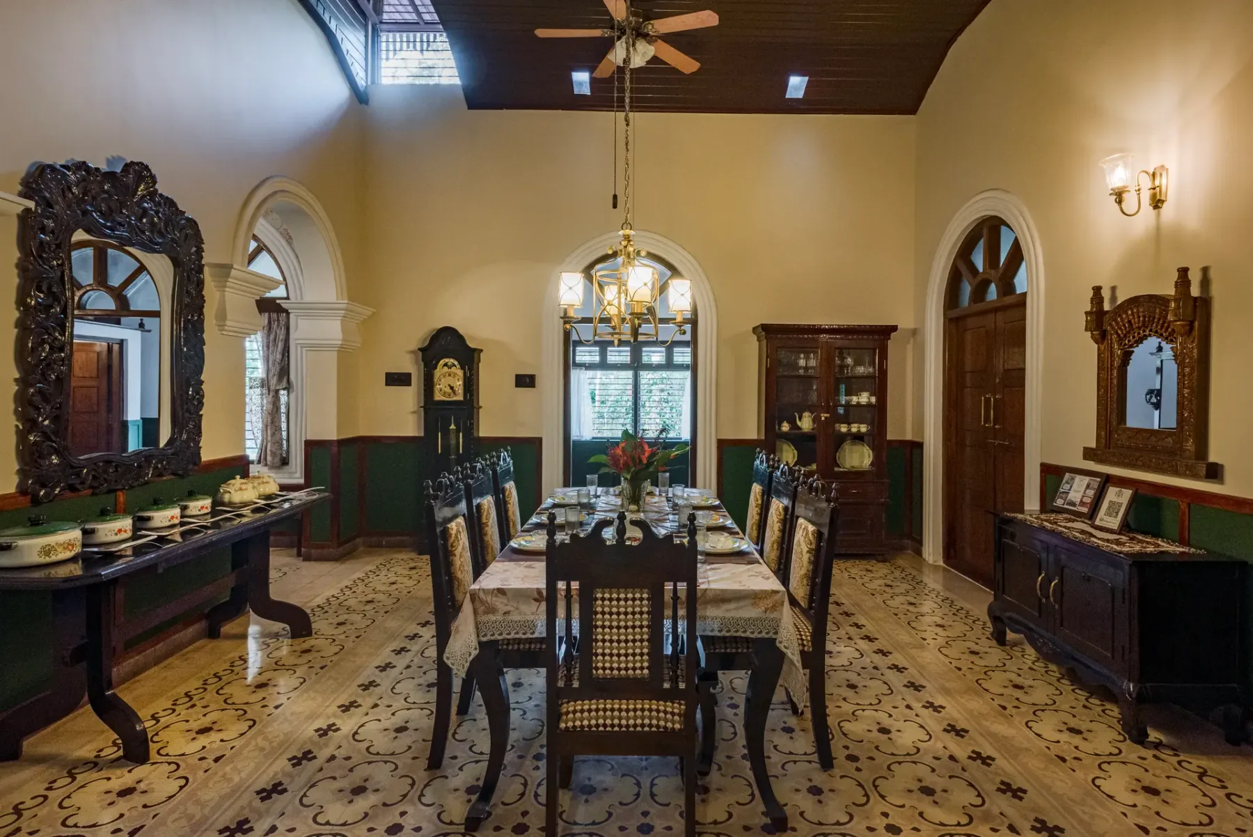 A formal dining room with a long table, chairs, and decorative mirrors.