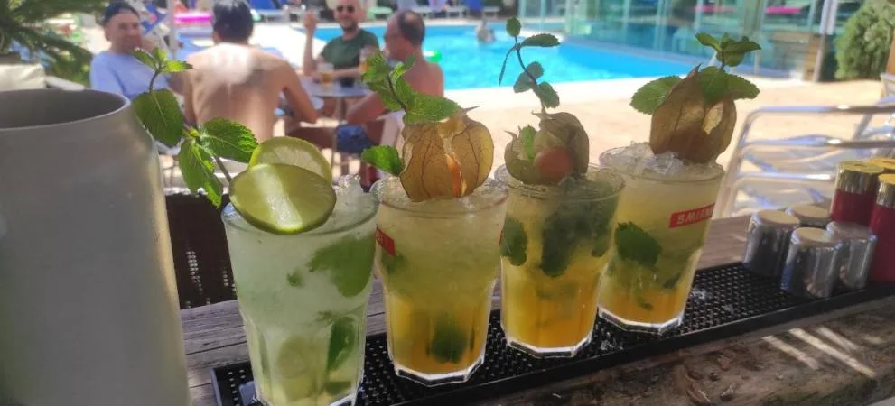 Piscina al aire libre con asientos y personas nadando