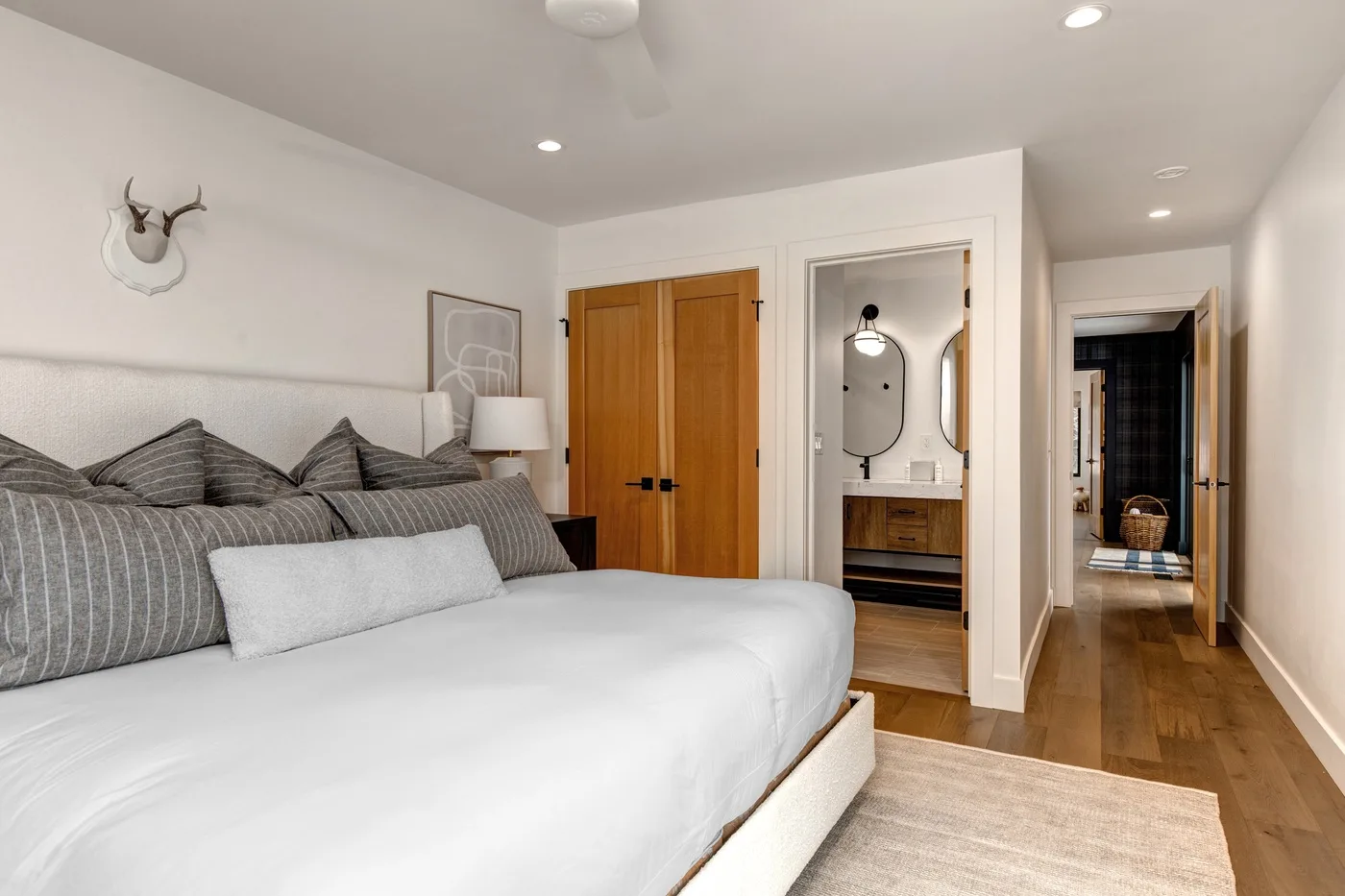 Un dormitorio con una cama grande, puertas de madera y un área de tocador.