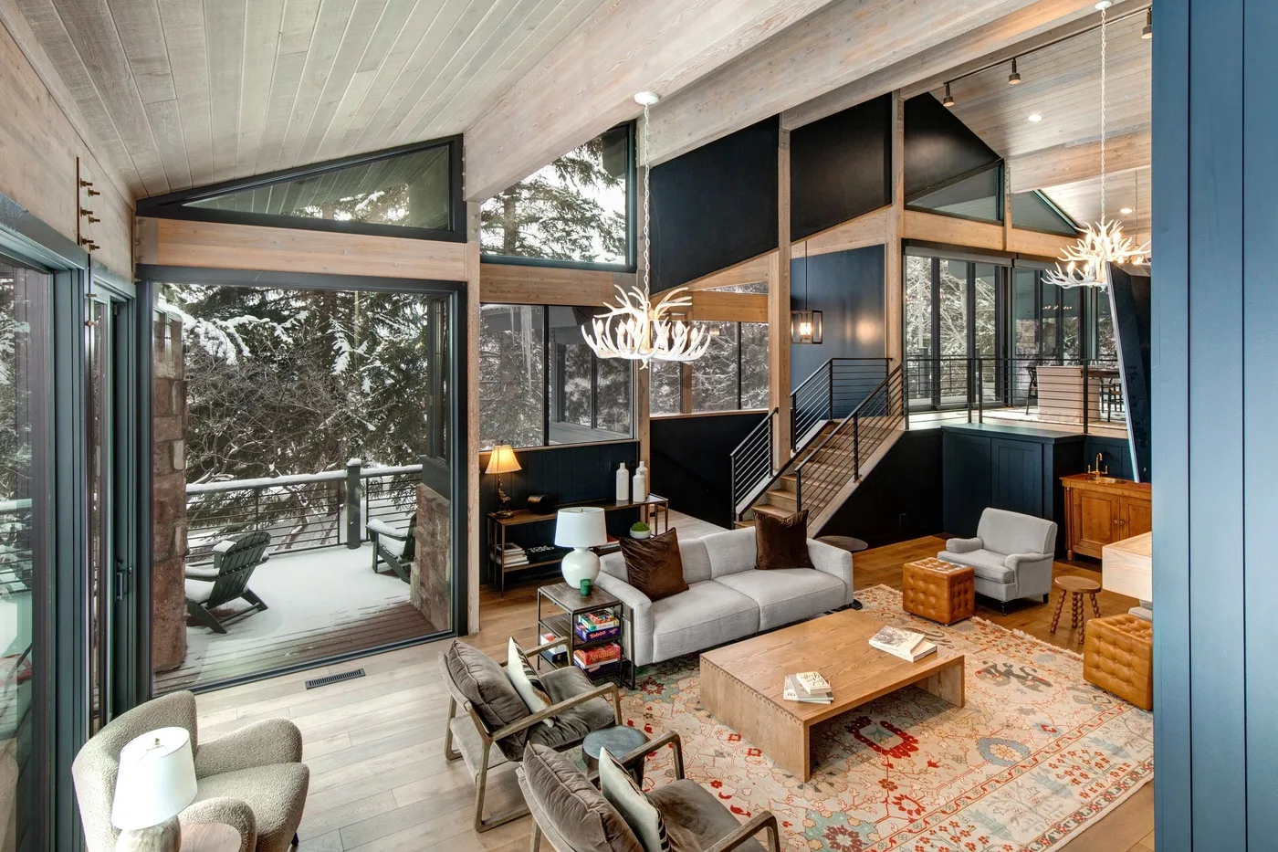 Una sala luminosa con grandes ventanales, asientos y una escalera.