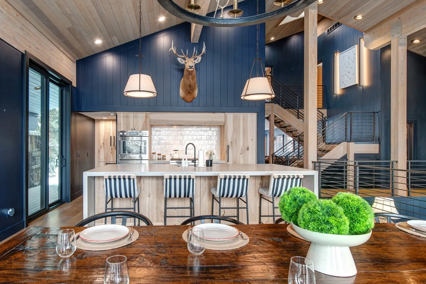 Una cocina abierta al comedor, con una isla larga y una mesa de madera.