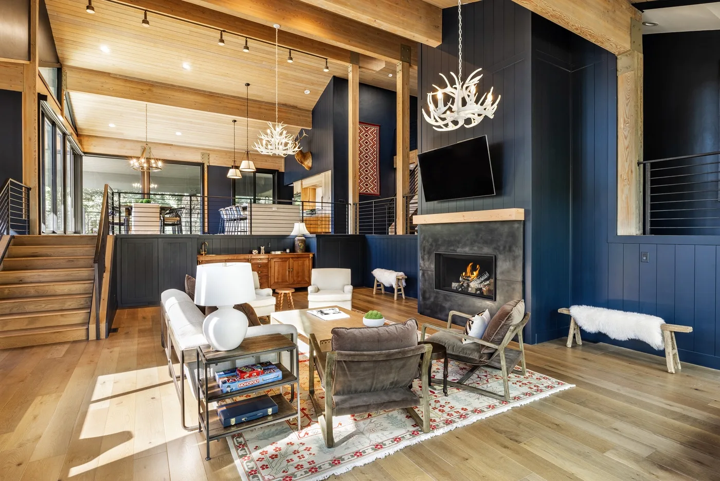 Una amplia sala de estar con chimenea, asientos y vigas de madera a la vista.