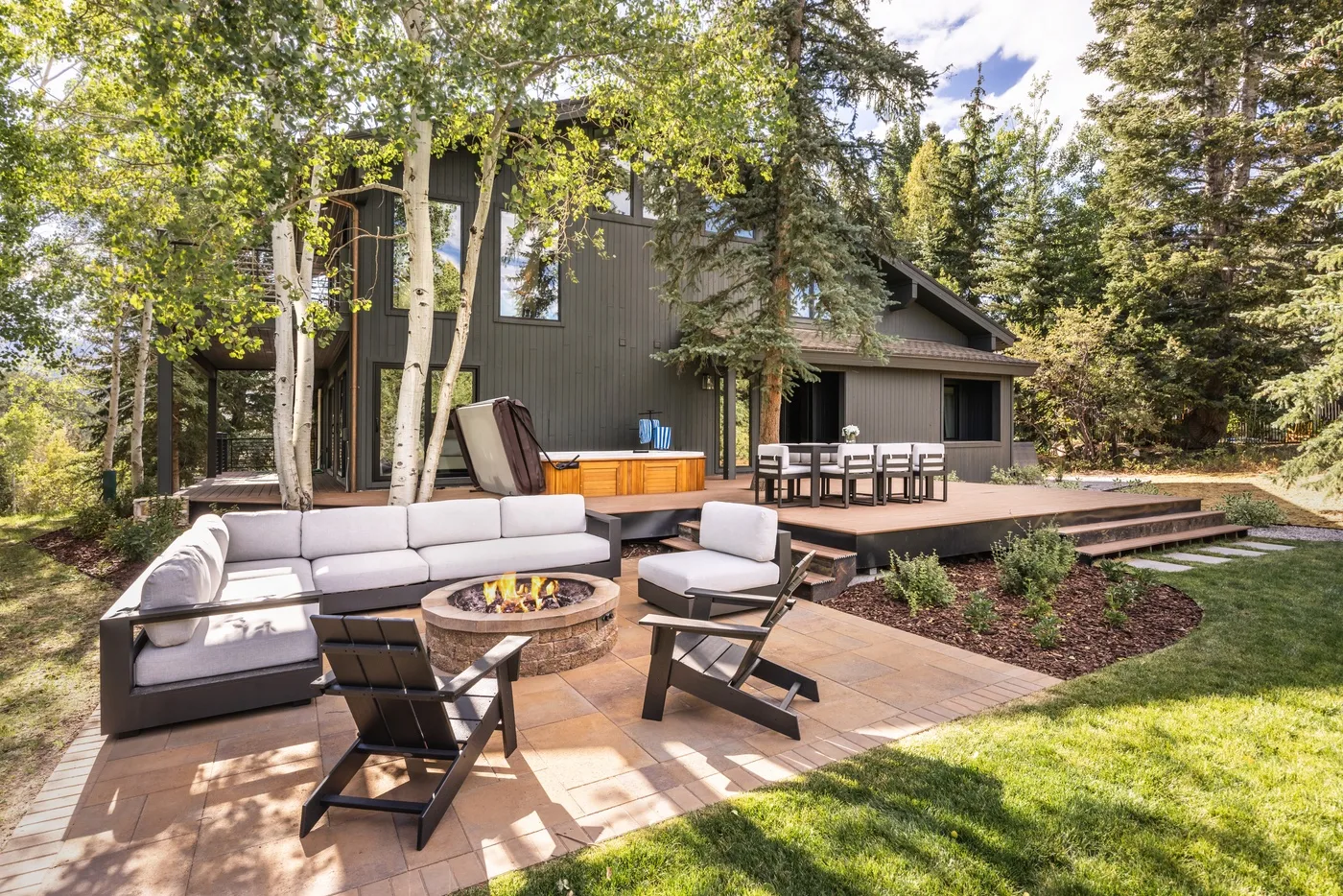 Un área de estar y comedor al aire libre junto a una casa moderna.