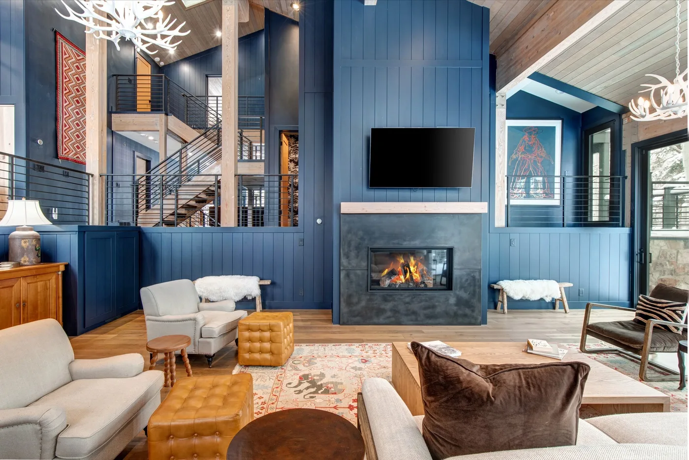 Una sala de estar amplia con paredes azules, una chimenea y asientos.