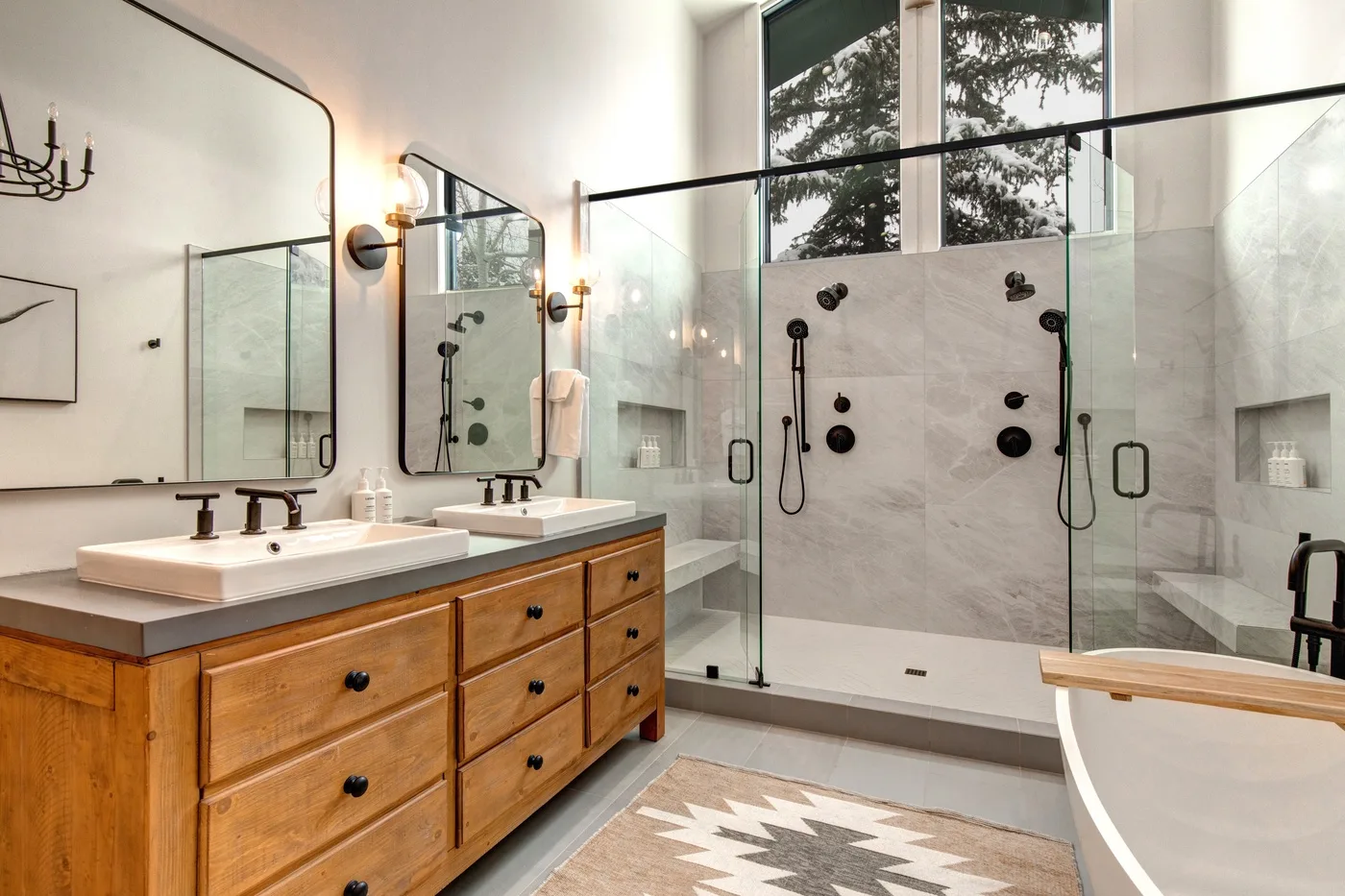 Un baño luminoso con muebles de madera, duchas de vidrio y una bañera.