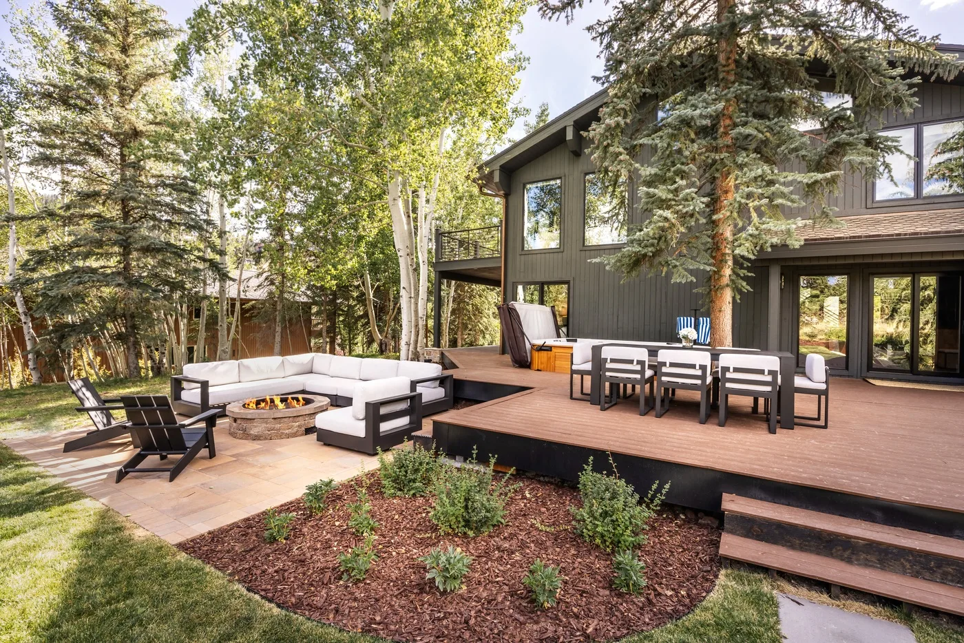 Una terraza exterior con mesa de comedor y asientos junto a una casa moderna.