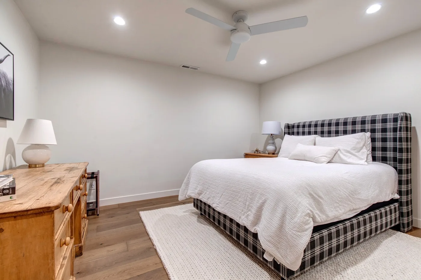 Dormitorio con cama, lámparas de noche y ventilador de techo.
