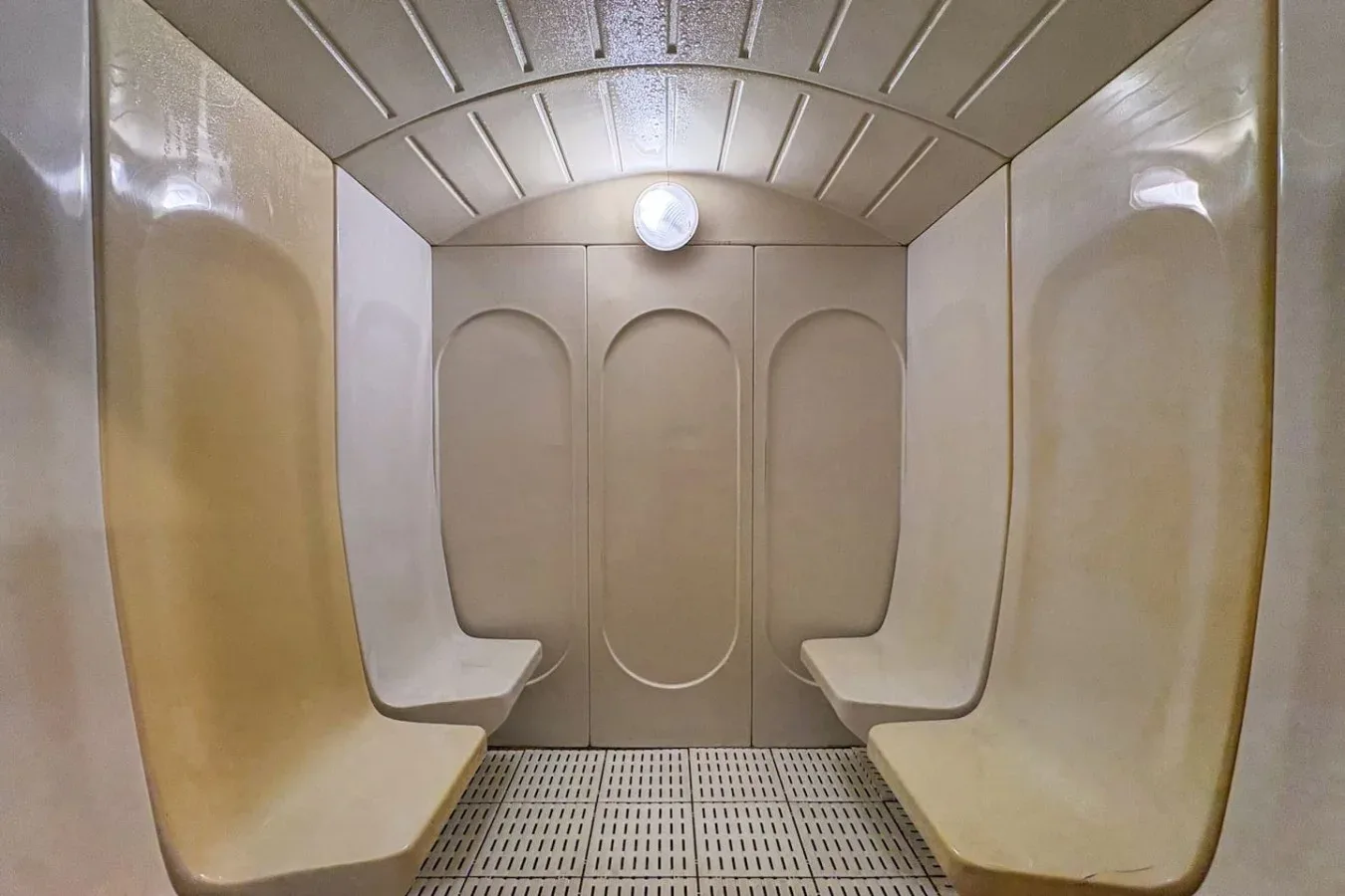 Un pequeño baño de vapor con asientos moldeados a ambos lados.