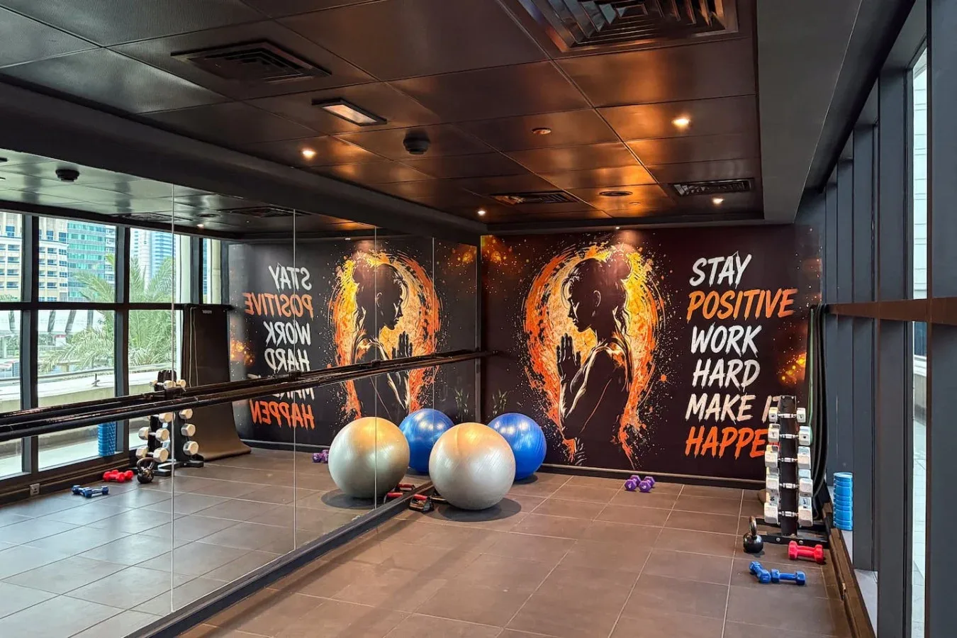 Una zona de ejercicio con pelotas de gimnasia y gráficos motivacionales en la pared.