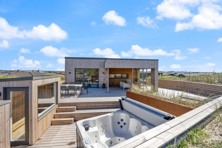 Una terraza exterior en la azotea con una bañera de hidromasaje y zona de descanso.