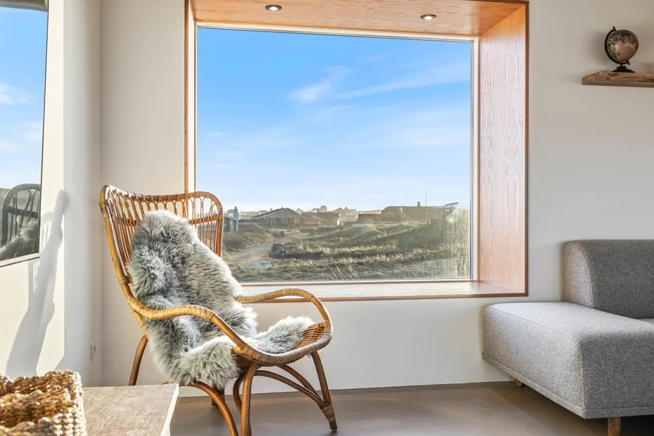 Una luminosa zona de estar con una gran ventana con vistas al paisaje.