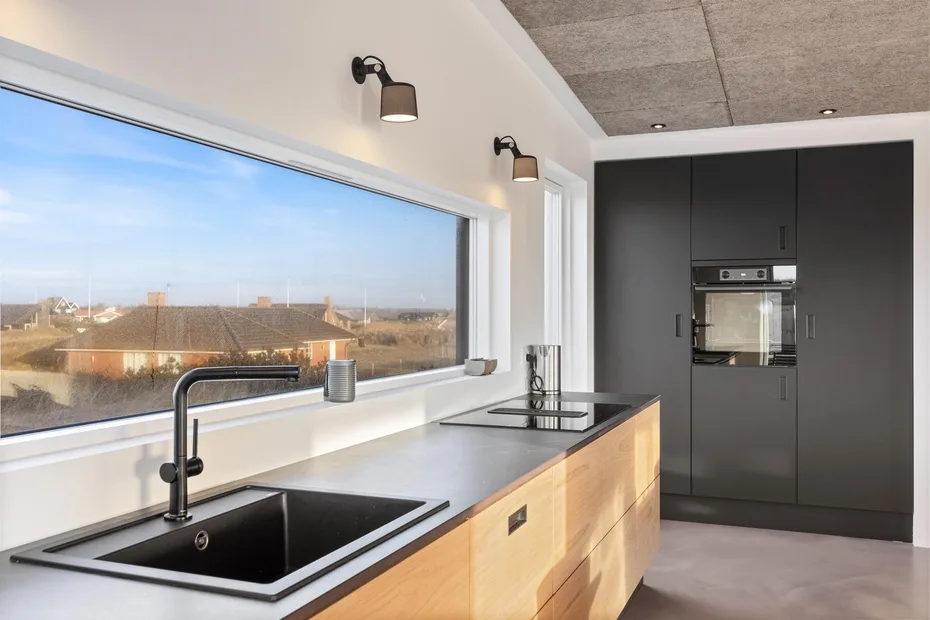 Una cocina moderna con una gran ventana que da a los tejados cercanos.
