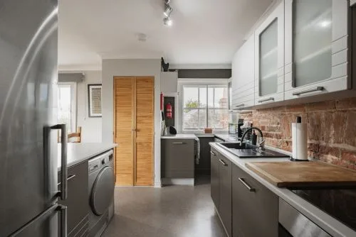 Una cocina moderna con gabinetes oscuros, un fregadero y una ventana.