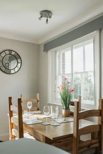 Un comedor con una mesa de madera junto a una ventana grande.