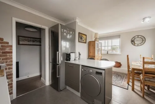 Una cocina con una lavadora junto a un comedor.