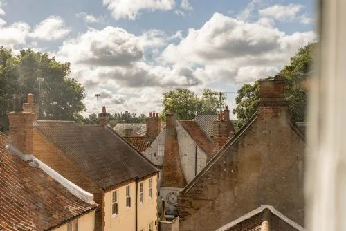 Vista de tejados y edificios cercanos bajo un cielo nublado.