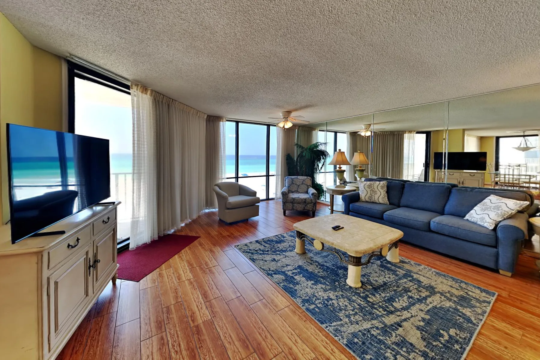 A living room with seating, a coffee table, and ocean views through large windows.