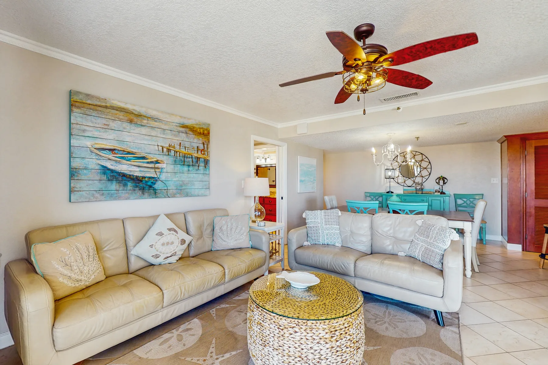 A living room with two sofas, a round coffee table, and colorful wall art.