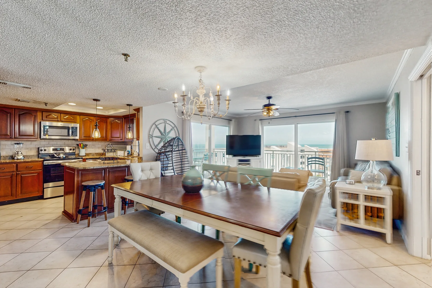 An open dining and kitchen area with a large table and sliding glass doors.