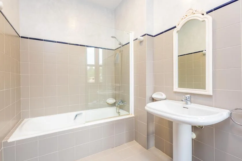 Un baño alicatado con bañera, ducha y lavabo con pedestal.