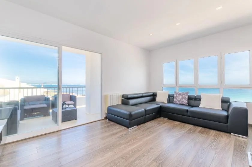 Una sala luminosa con asientos oscuros y ventanas con vistas a un balcón.