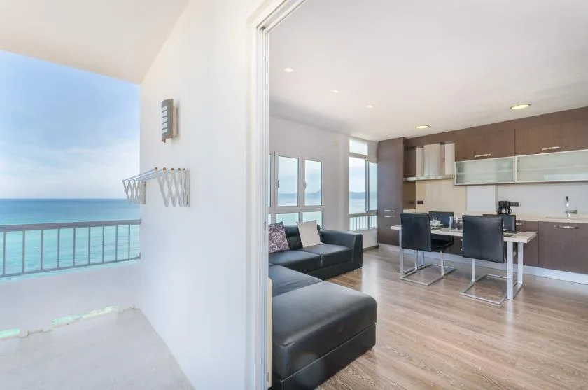 Una moderna zona de estar y comedor se abre a un balcón con vistas al mar.