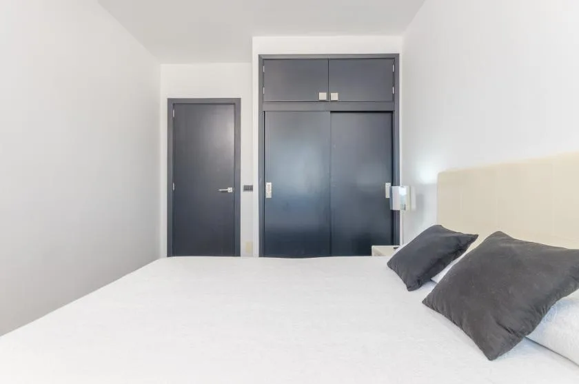 Un dormitorio con una cama y armarios empotrados oscuros.