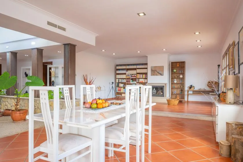 An open dining and living area with a white table and bookshelves.