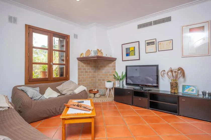 A living room with seating, a television, and a wooden coffee table.