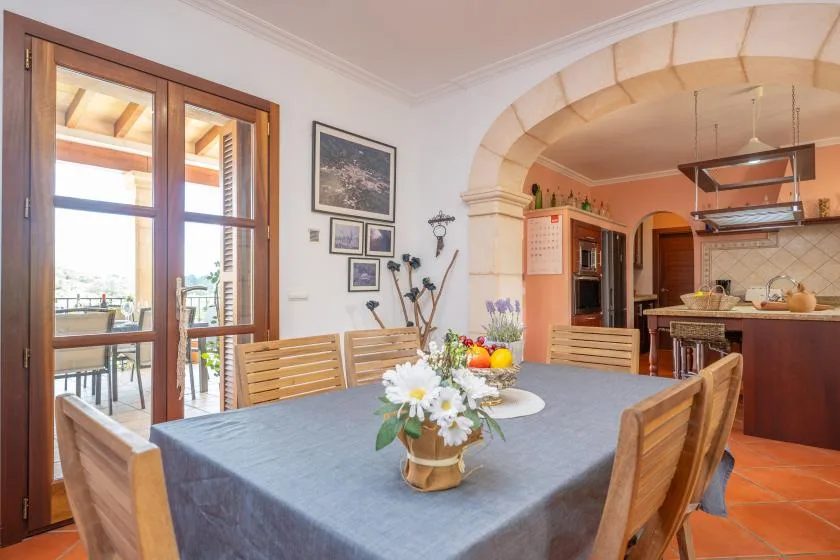 A dining area with a set table and an open kitchen beyond.