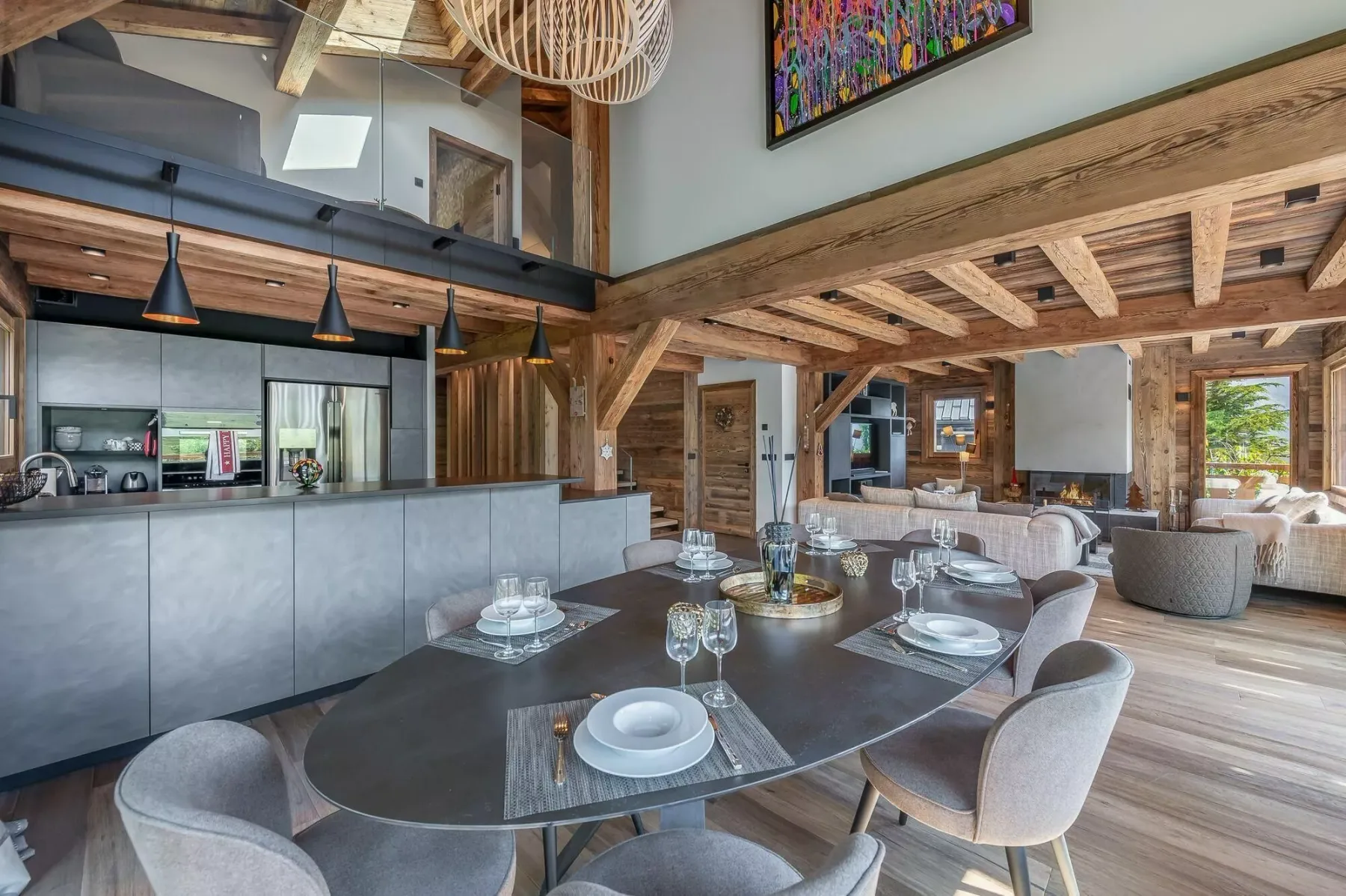 A dining area with a long table set with plates and glasses.