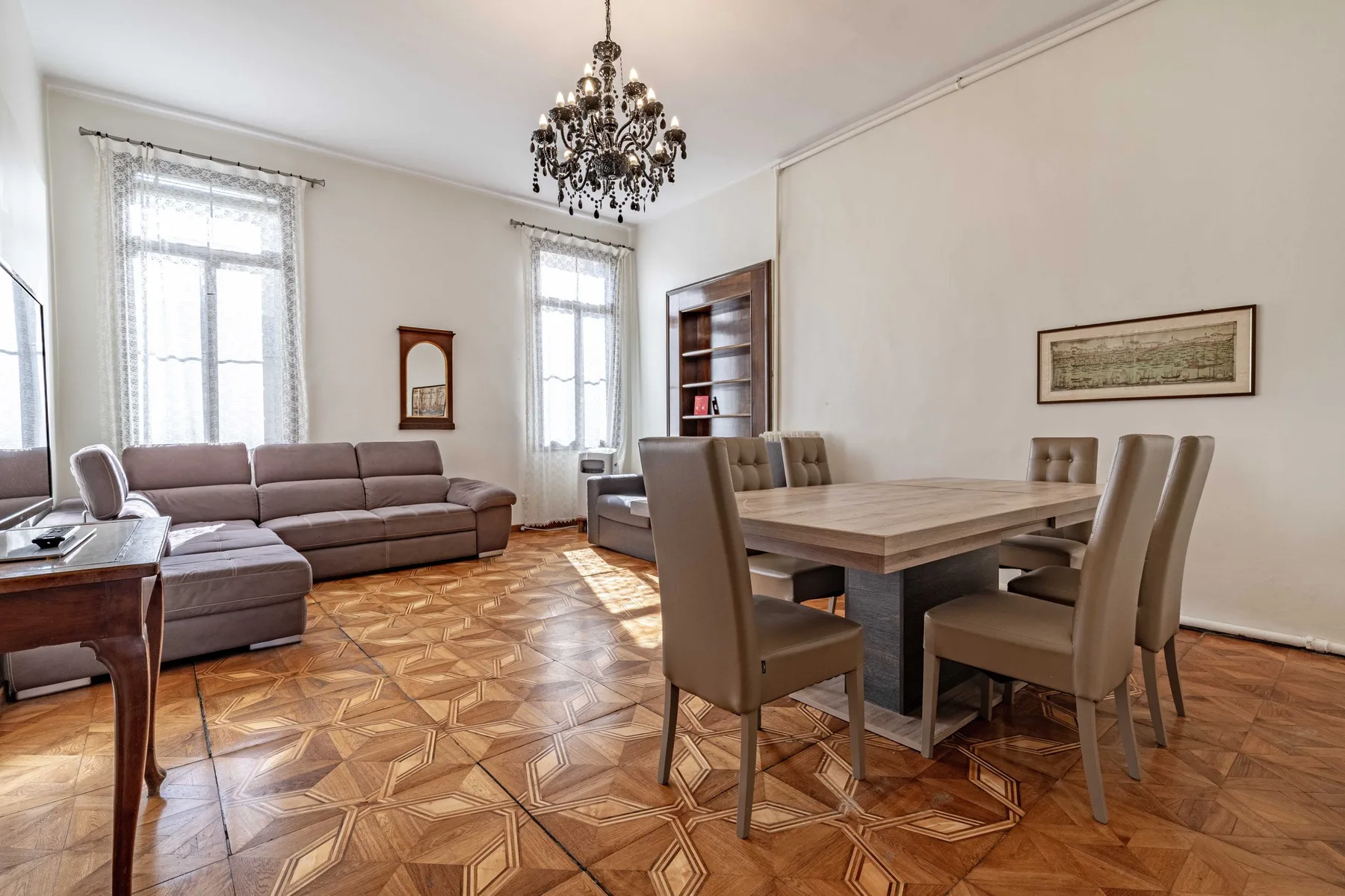 A living and dining room with upholstered seating and a large dining table.
