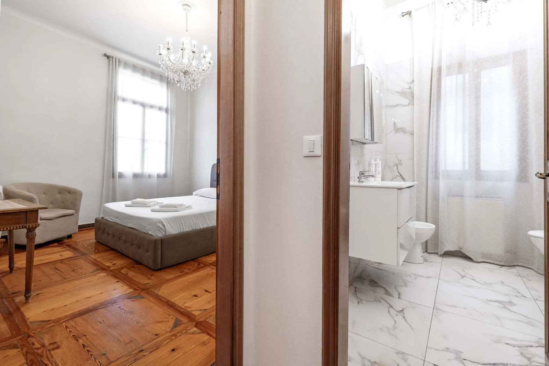 A bedroom and adjoining bathroom are visible through the open doorway.