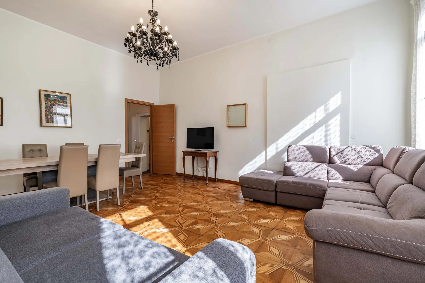 A bright living room with a sectional seating area and television.