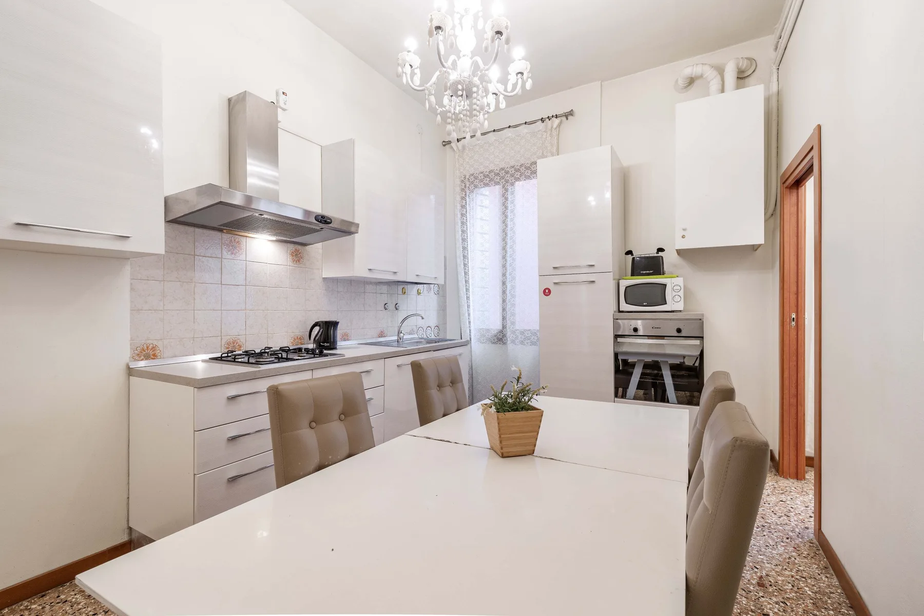 A bright kitchen and dining area with white cabinetry and a table.