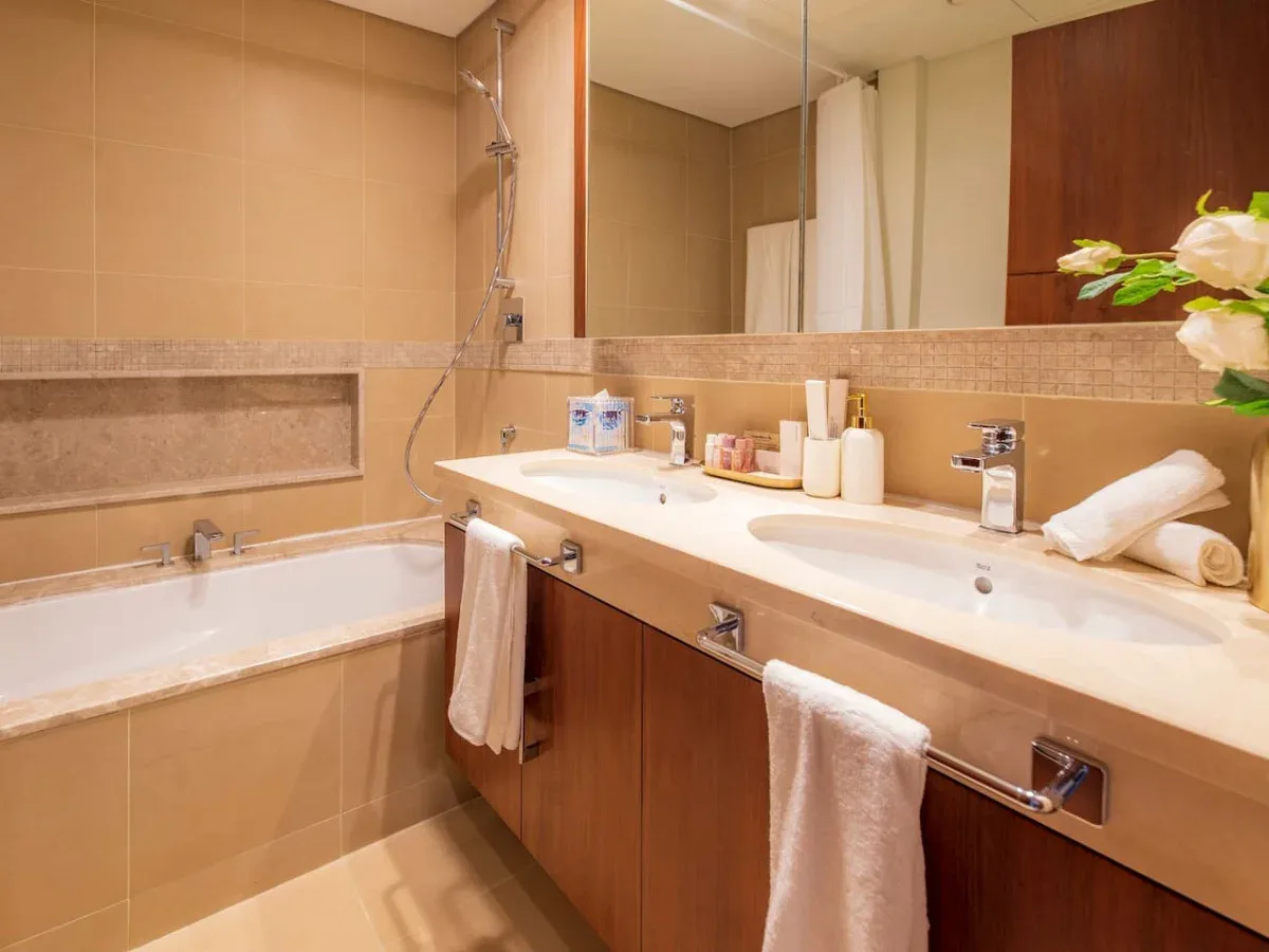 A tiled bathroom with a bathtub, a shower, and a long vanity.