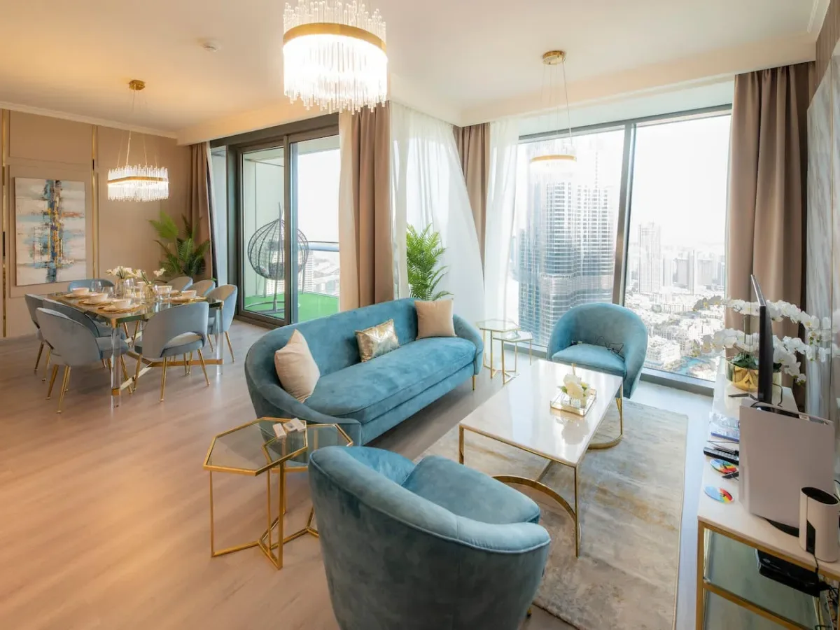 A bright living and dining area with blue seating and large windows.