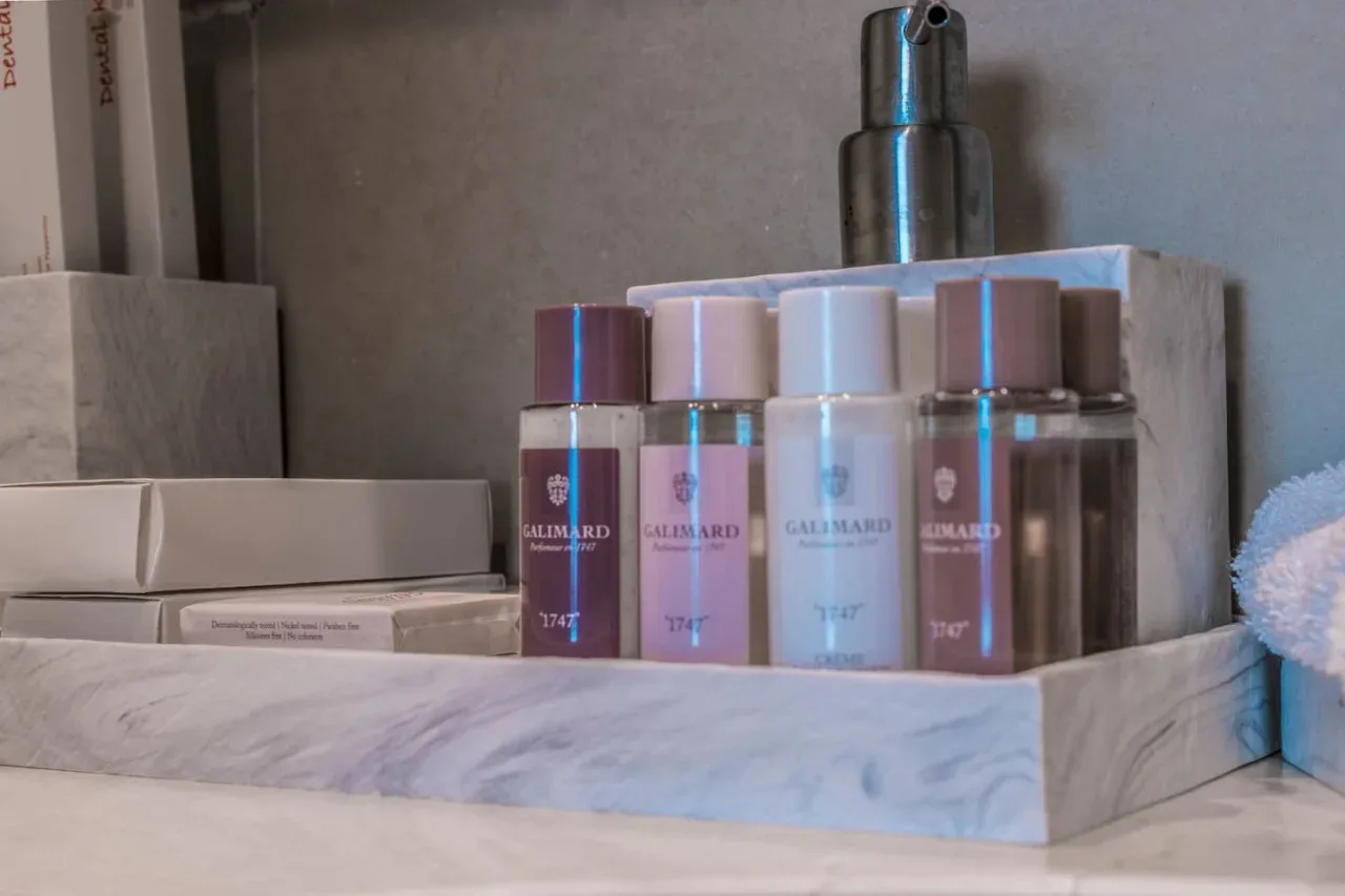 Toiletries and a pump dispenser are arranged on a bathroom counter.