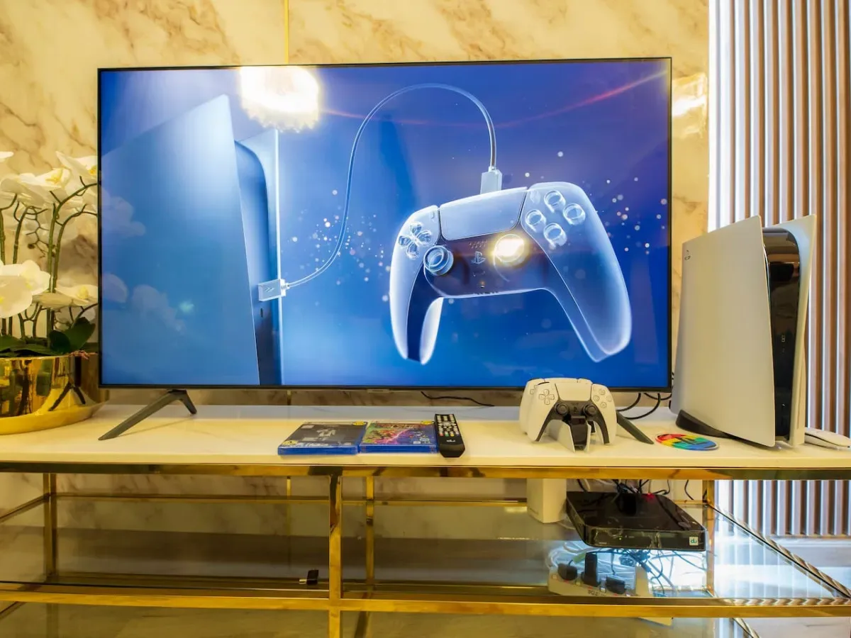 A gaming setup with a large television displaying a console and controller.