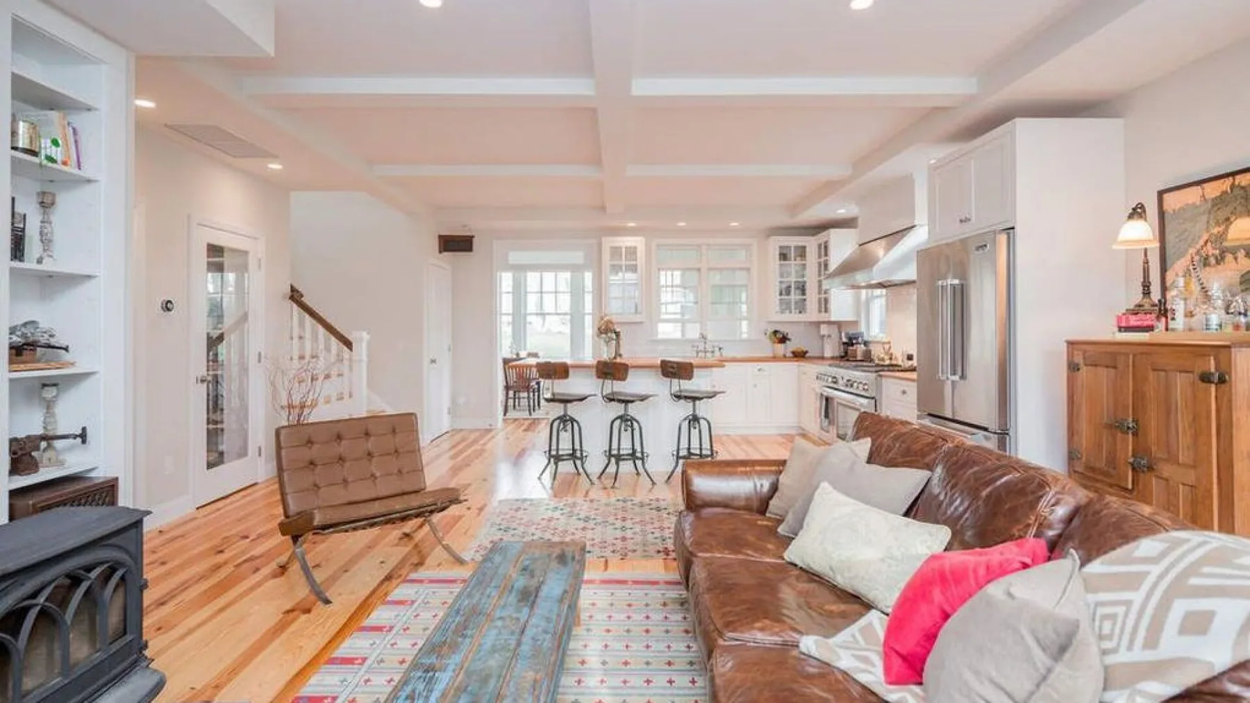 A bright open-plan living room and kitchen with a dining counter.