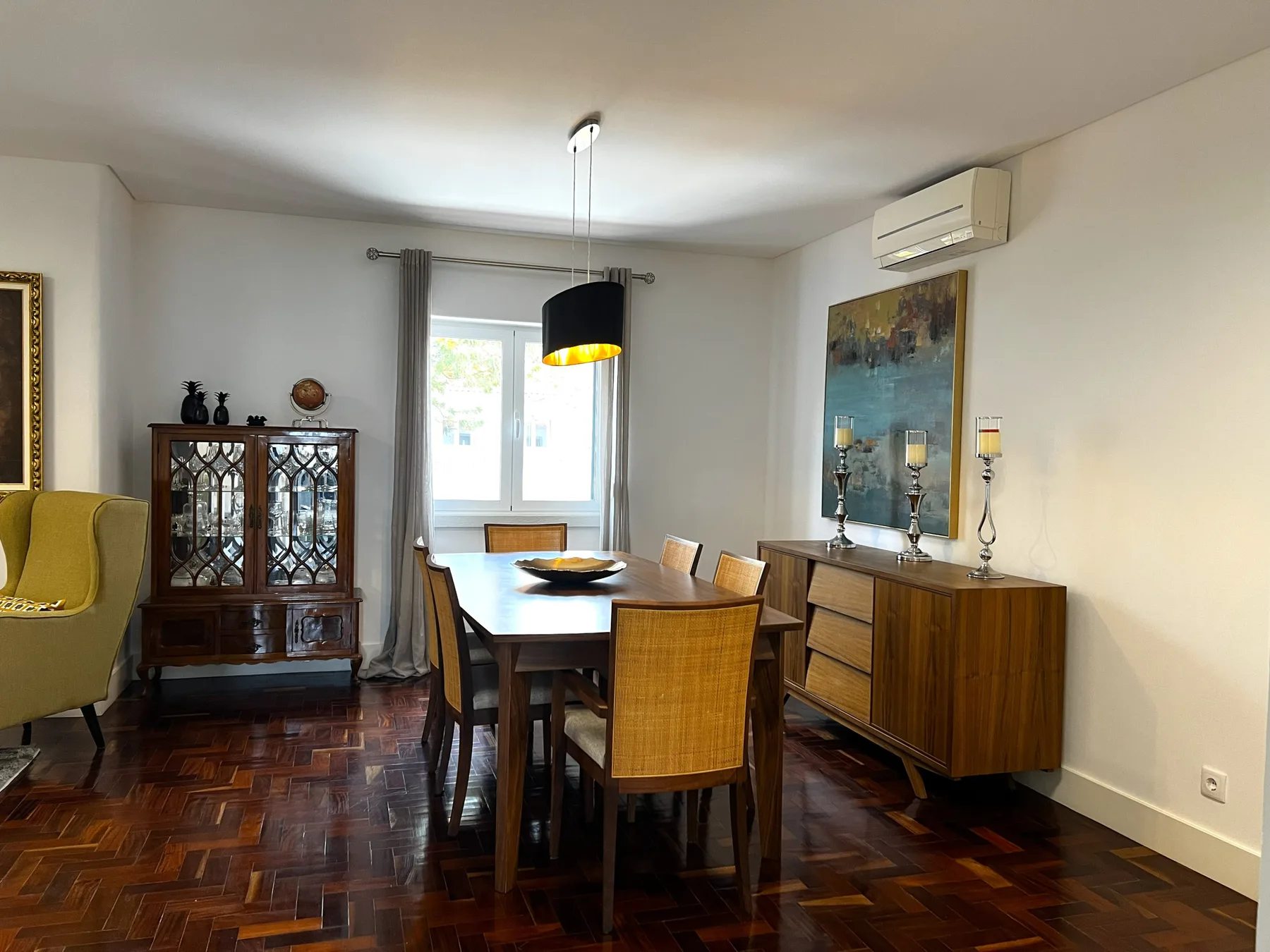 Comedor con una mesa de madera y sillas junto a una ventana luminosa.