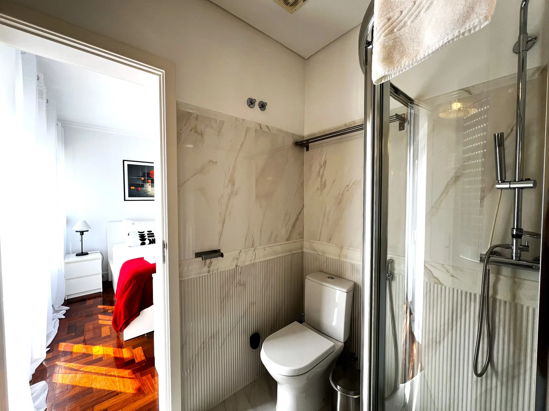 Un baño alicatado con un inodoro y una ducha de cristal.