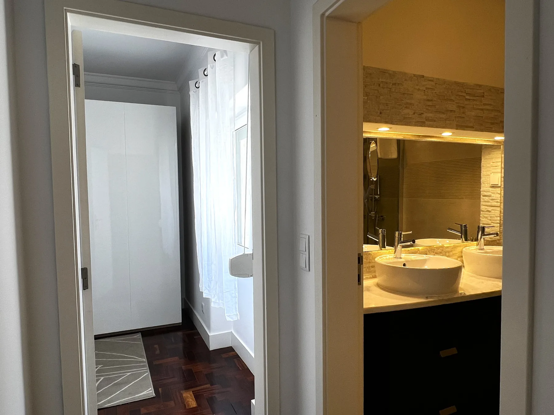 Un baño con un lavabo y una zona de ducha visibles desde la puerta.