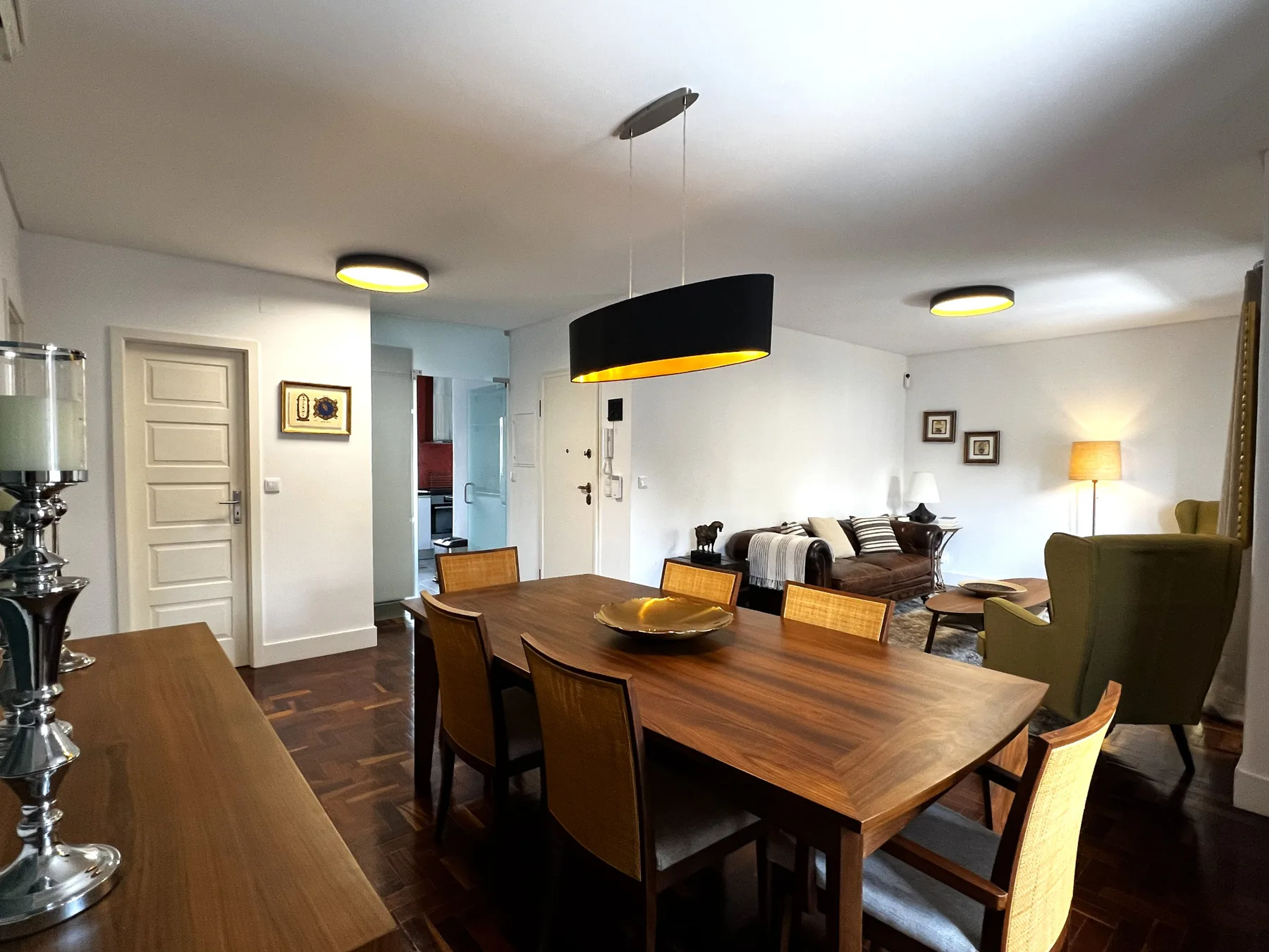Un comedor y sala de estar con una mesa de madera y asientos.