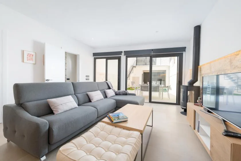 A bright living room with gray seating, a coffee table, and glass doors.
